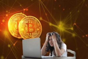 bitcoin e donna disperata di fronte a pc