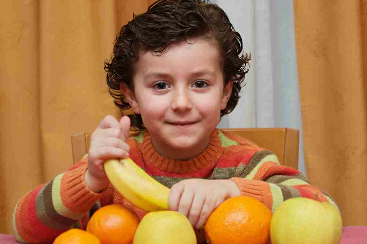 bambino mangia frutta